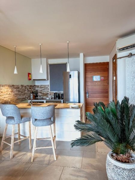 Cocina moderna con barra de desayuno y sillas altas en suite del AQUA Boutique Hotel