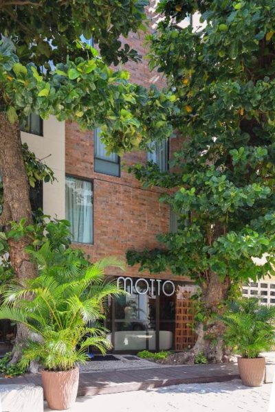 Fachada exterior del Motto by Hilton Recife con vegetación tropical y entrada principal de ladrillo
