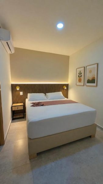 Habitación doble con cabecero de madera e iluminación ambiental en Hotel Nakama