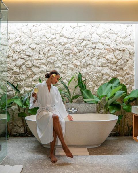 Bañera exenta de piedra en el spa del Lomo Boutique Hotel & Villas de Uluwatu con decoración tropical