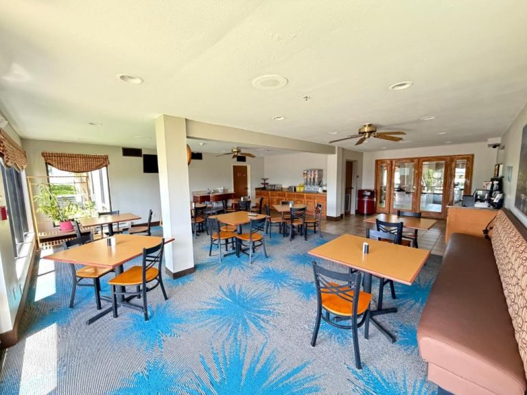 Salón de desayuno con mesas y sillas del Days Inn & Suites by Wyndham Cuba, alfombra azul tropical