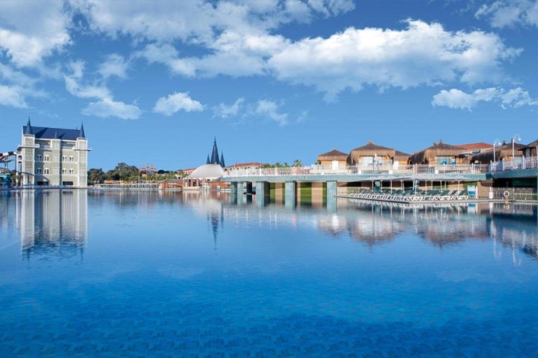 Laguna principal con puente y bungalows sobre el agua en Granada Luxury Belek Family Kids Concept