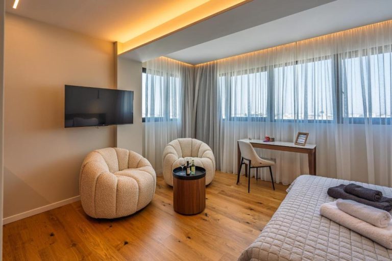 Suite moderna con sillones bouclé, escritorio y TV de pared en Sky Suites Nicosia