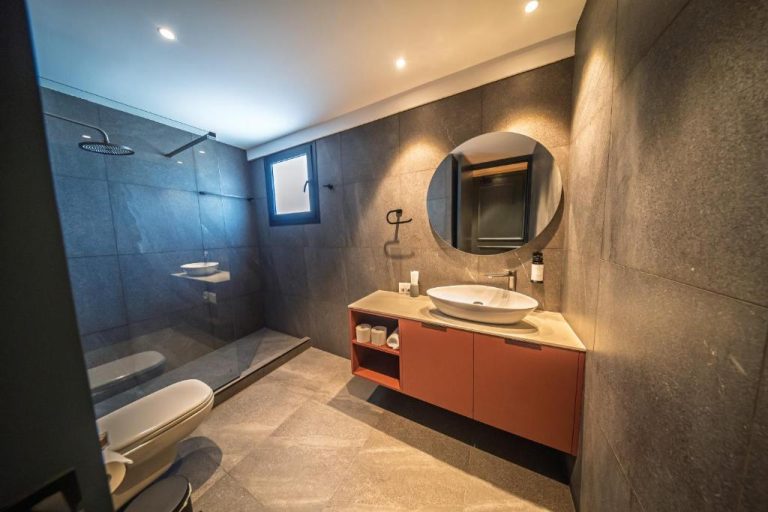 Baño moderno con ducha de lluvia y lavabo sobre encimera en Sky Suites Nicosia