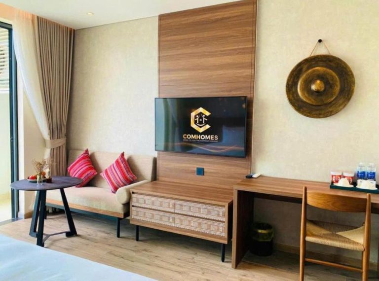 Habitación con salón, televisor y escritorio en el hotel Panorama Beach Win Nha Trang