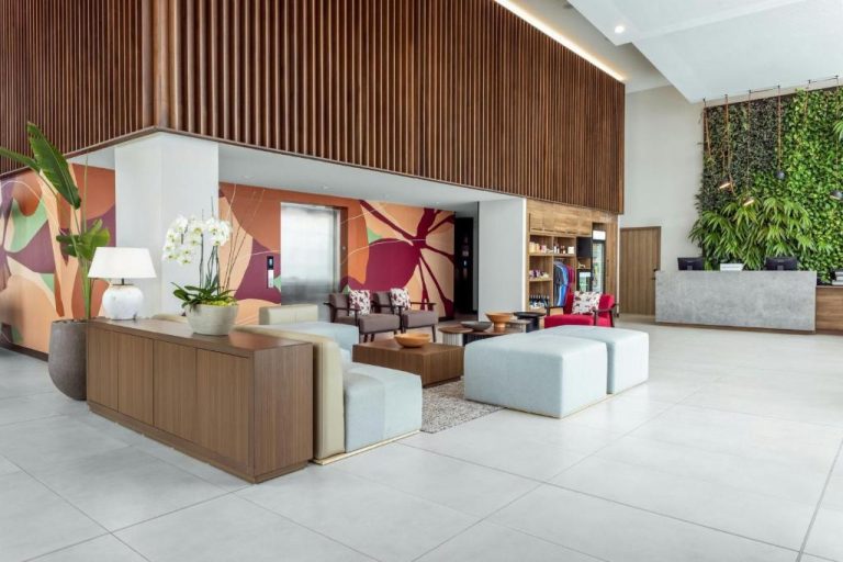Lobby moderno con recepción y jardín vertical del Residence Inn by Marriott San Jose Alajuela el Coyol