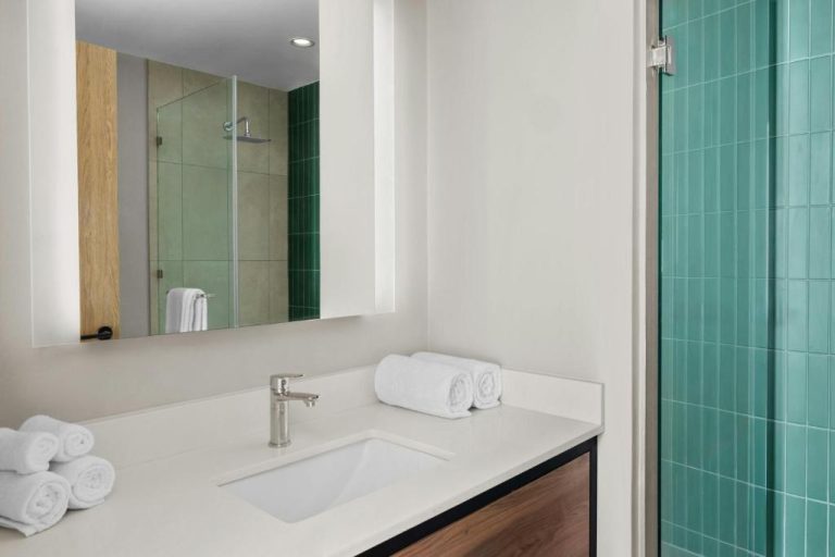 Baño moderno con ducha de azulejos verdes en Residence Inn by Marriott San Jose Alajuela El Coyol