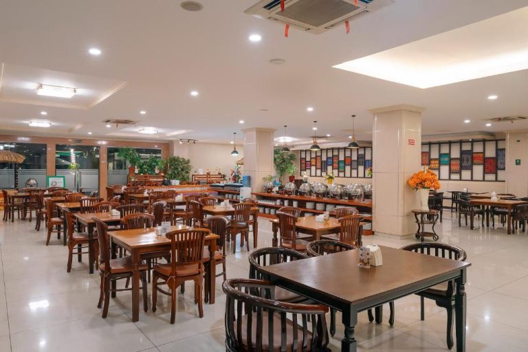 Amplio restaurante buffet con mesas de madera y zona de servicio en el Hotel Puri Indah & Convention