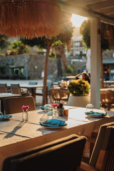Terraza del restaurante exterior del Radisson Collection Hotel Bodrum con mesas decoradas al atardecer