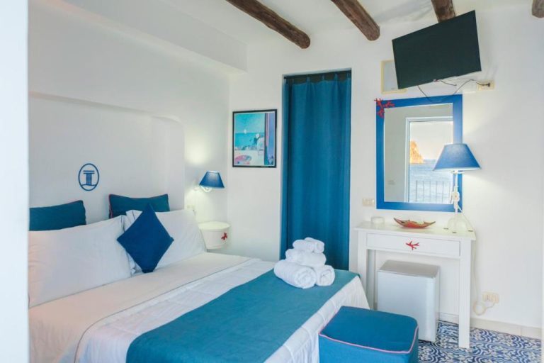 Habitación doble con decoración en azul y blanco y vista al mar en Hotel La Terrazza
