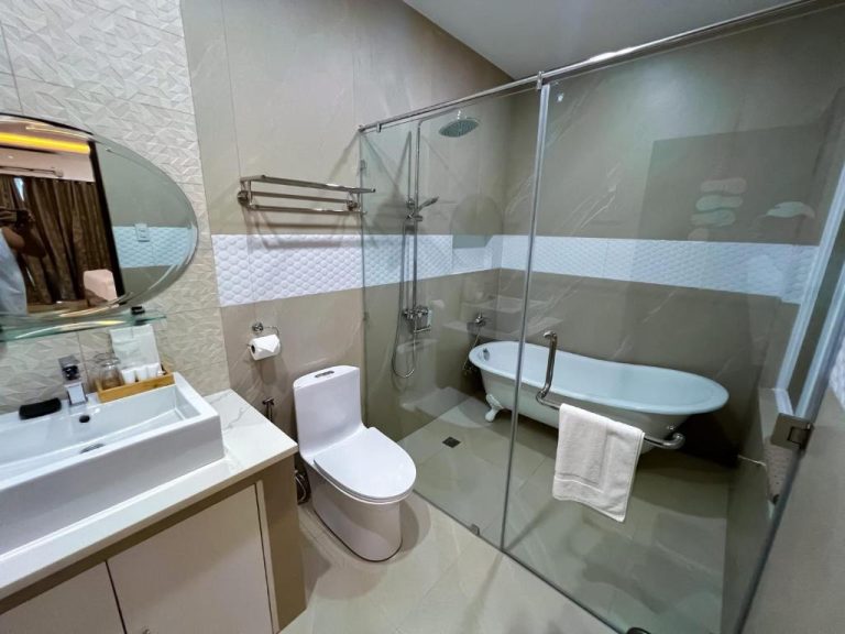 Baño moderno con bañera clásica, ducha y lavabo del hotel Yuhum Boracay Suites