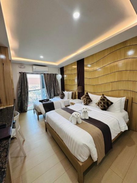 Habitación doble de lujo con dos camas y cabecero de madera en Yuhum Boracay Suites