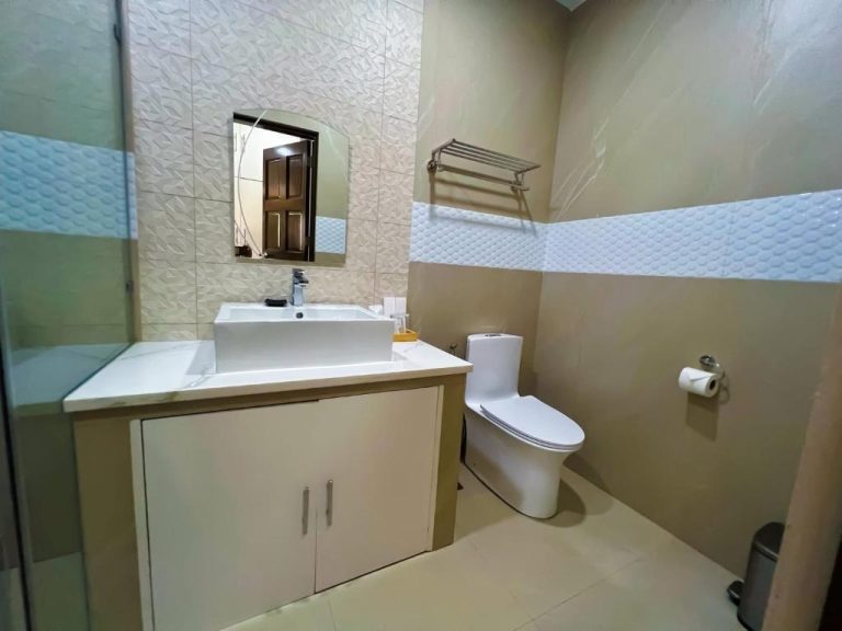 Baño privado moderno con lavabo, inodoro y ducha de cristal en Yuhum Boracay Suites