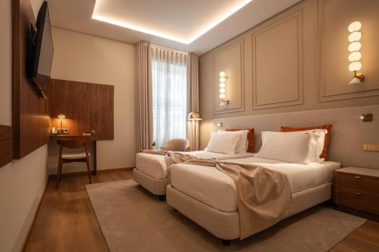 Habitación twin con dos camas individuales y decoración elegante en tonos beige en The Book Hotel
