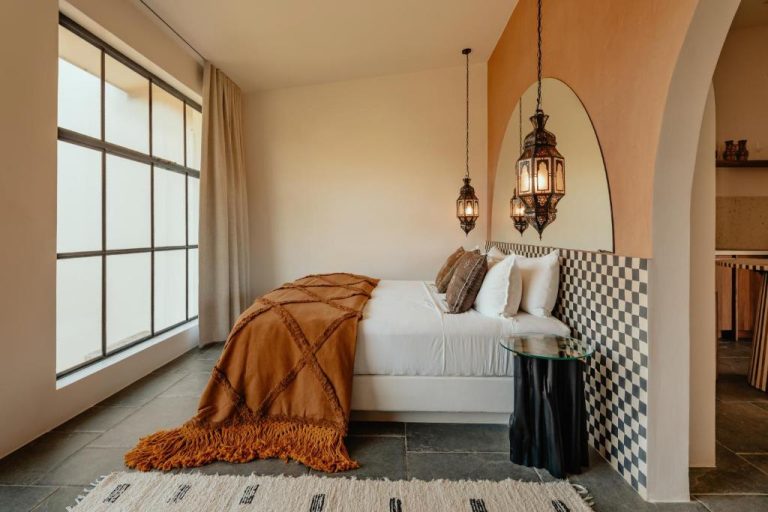 Habitación de estilo marroquí con lámparas artesanales y manta naranja en Domo Nosara Boutique Hotel