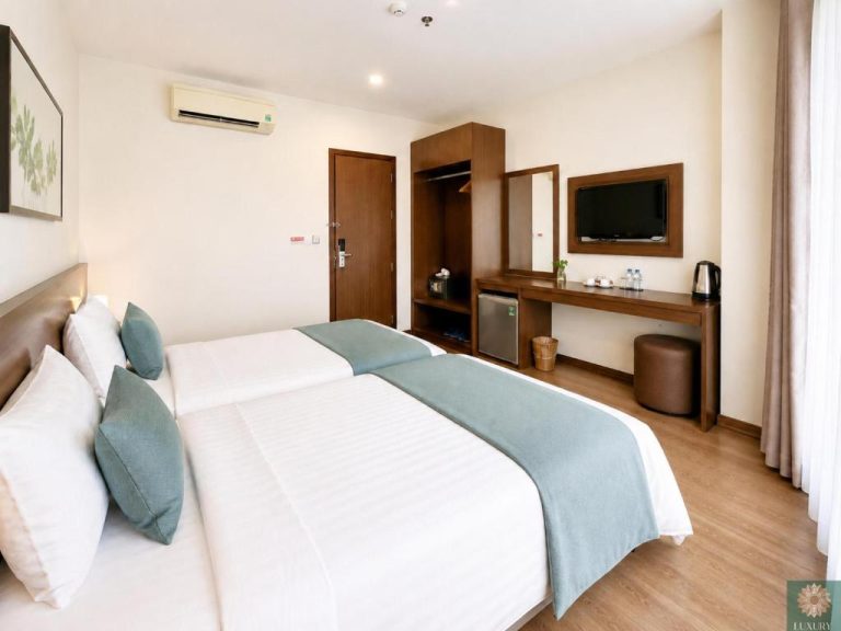 Habitación twin con dos camas y escritorio de madera en Corner Central Danang City Hotel