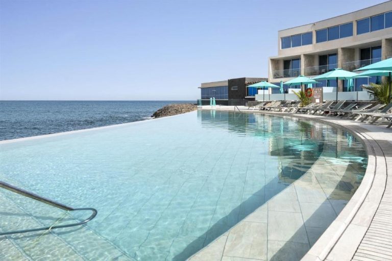 Piscina infinita con vistas al océano del Barceló Praia Cape Verde con tumbonas y sombrillas turquesa