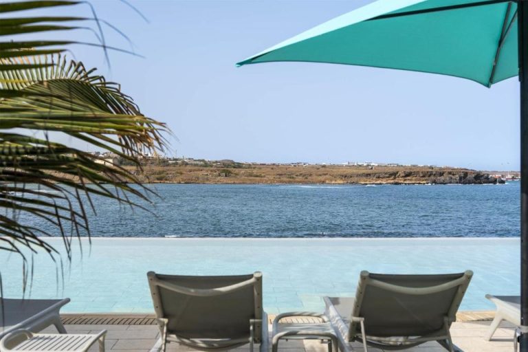 Piscina infinita con tumbonas y sombrilla del Barceló Praia Cape Verde con vistas al océano