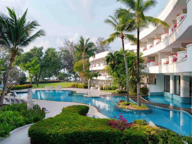 Piscina exterior con palmeras y jardines tropicales del Novotel Rayong Rim Pae Resort en Tailandia