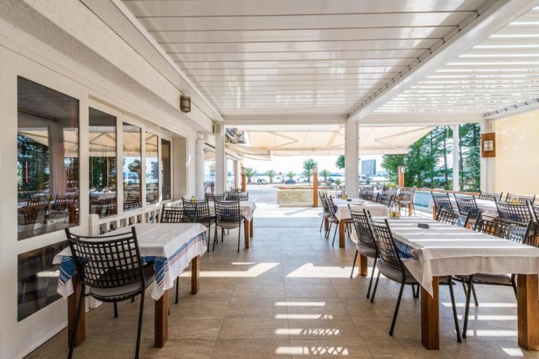 Terraza restaurante del Hotel Joso con mesas y sillas con vistas al mar y jardines