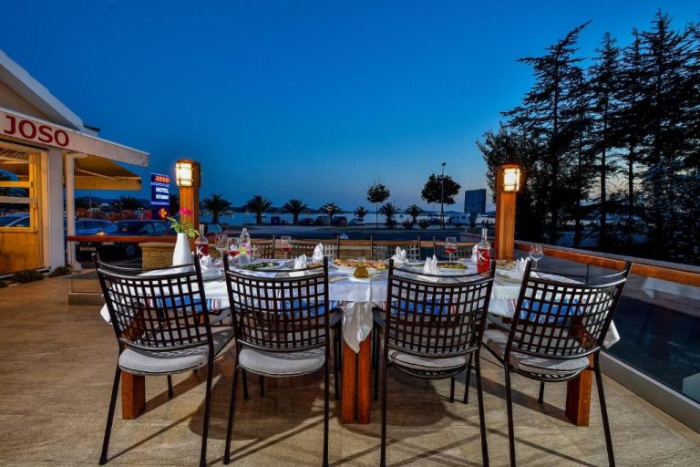 Terraza exterior del restaurante Hotel Joso con mesa preparada para cenar y vistas al mar al atardecer