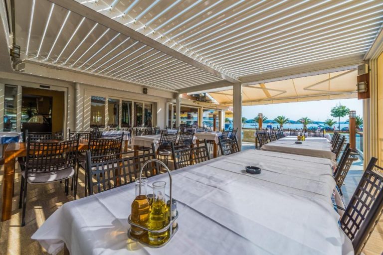 Terraza exterior del restaurante Hotel Joso con mesas blancas y vistas al mar
