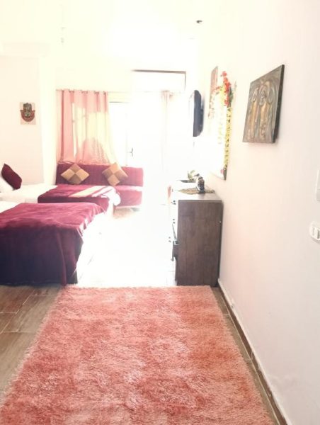 Habitación doble con camas en color rojo y alfombra rosa en el Resort Florenza