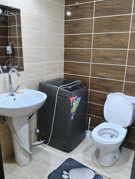 Baño completo con lavadora, inodoro y lavabo en habitación del Resort Florenza