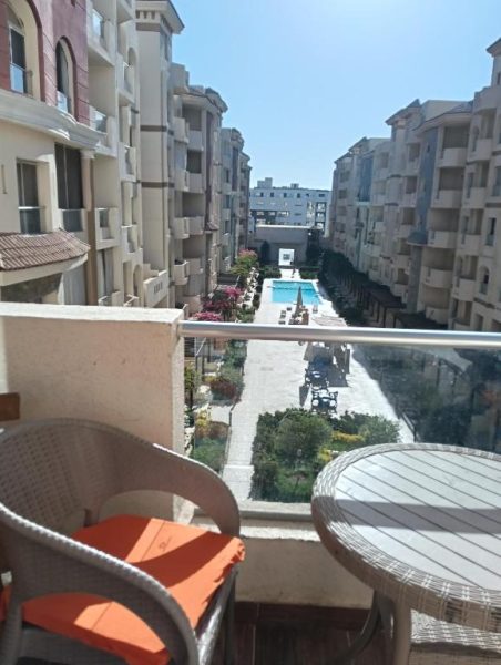 Vista desde balcón con terraza del Resort Florenza hacia la piscina comunitaria rodeada de edificios