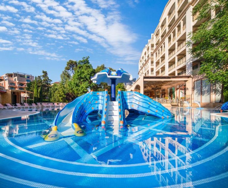 Piscina exterior con toboganes infantiles azules del Hotel Alba All Inclusive en día soleado