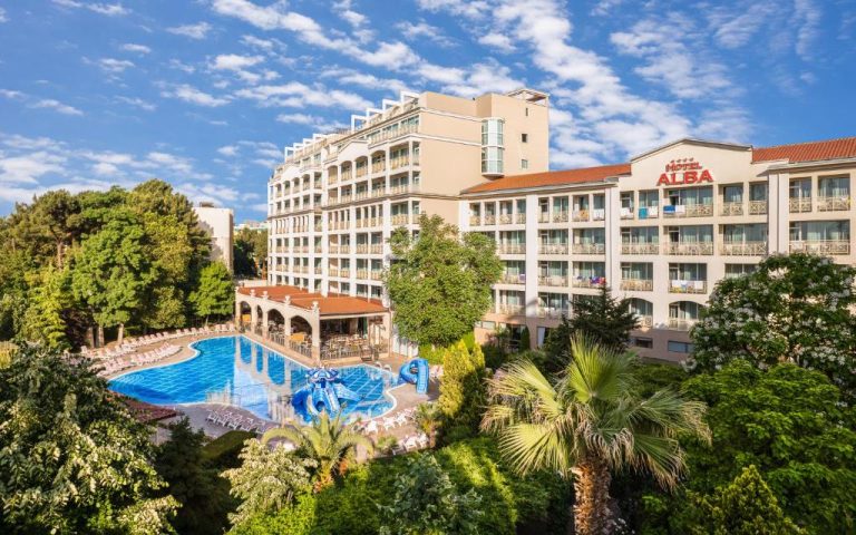 Vista aérea de la piscina exterior con toboganes acuáticos del Hotel Alba All Inclusive rodeado de jardines