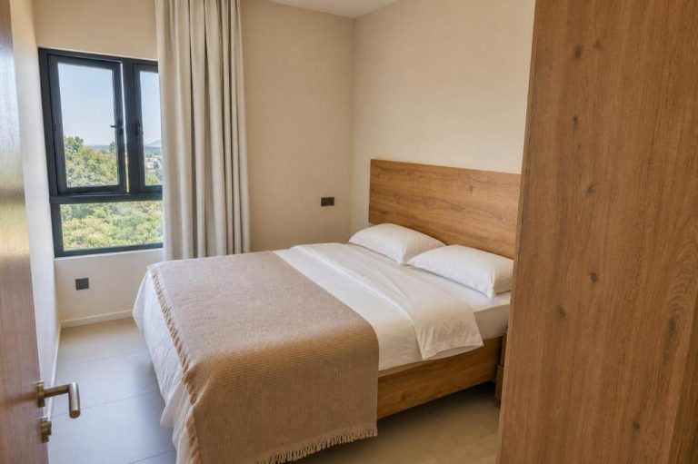 Habitación doble con cabecero de madera y vistas al jardín en Minissy Suites