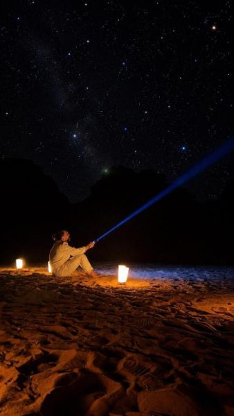 Observación de estrellas en el desierto de noche con linterna en Wadi Rum Bella Rose Luxury Camp