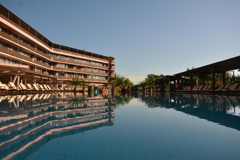Piscina infinita exterior con tumbonas y edificio principal del Sunny Beach Club Adults Only