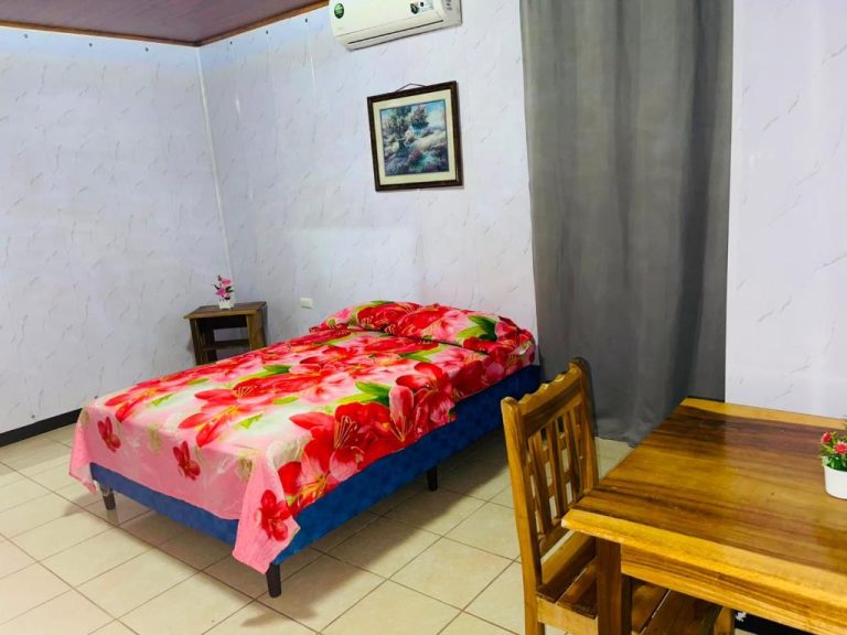 Habitación individual con cama floral y aire acondicionado en Hostal Pequeña Habana