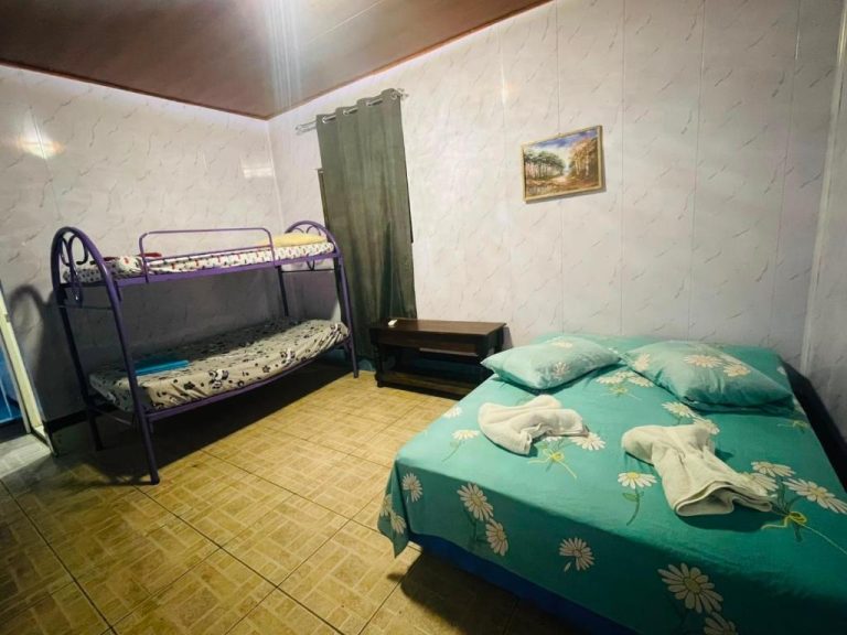Habitación triple con cama doble y litera metálica en Hostal Pequeña Habana