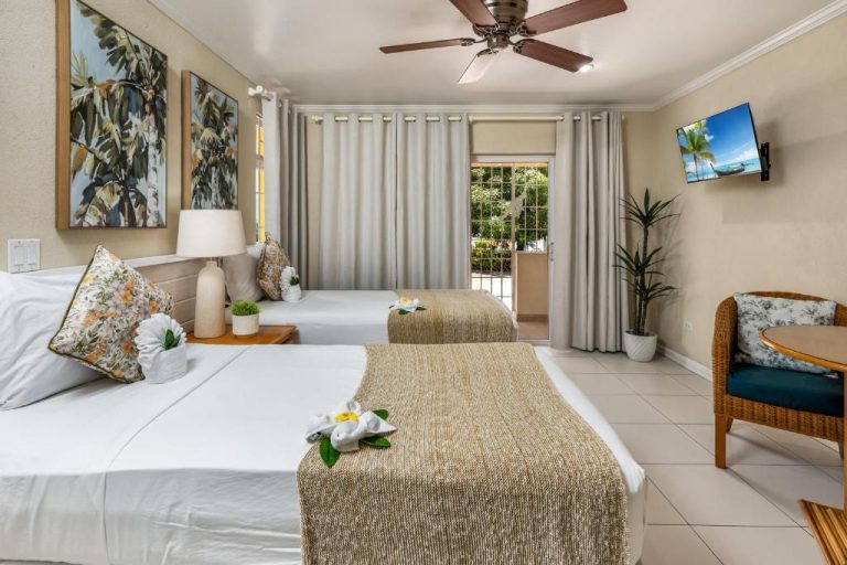 Habitación doble con dos camas y decoración tropical en Adulo Apartments con TV y terraza