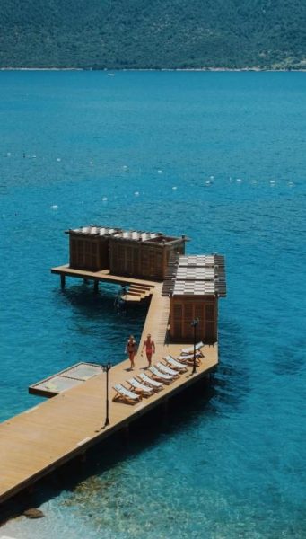 Muelle privado sobre el mar turquesa con tumbonas y bungalows flotantes en Casa Nonna Bodrum Adult Only