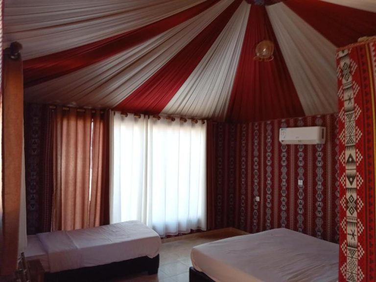 Habitación doble en tienda de campaña con techo rojo y blanco en Wadi Rum Luxury Nature Luxury
