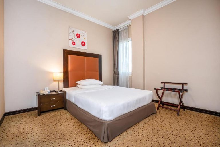 Habitación individual con cama doble y cabecero naranja en Kingsgate Hotel Doha by Millennium Hotels
