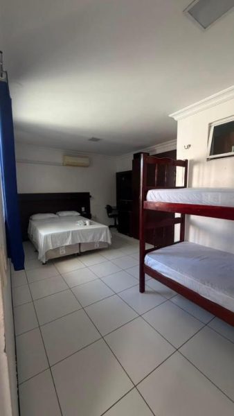 Habitación familiar con cama doble y literas de madera en Hotel Sol Brasil