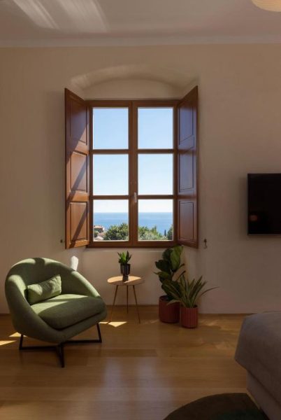 Habitación luminosa con ventana arqueada y vistas al mar en Palace Natali