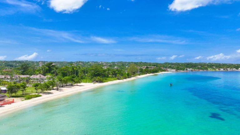 Vista aérea de la playa de aguas turquesas y arena blanca frente a Shields Negril Villas en Jamaica