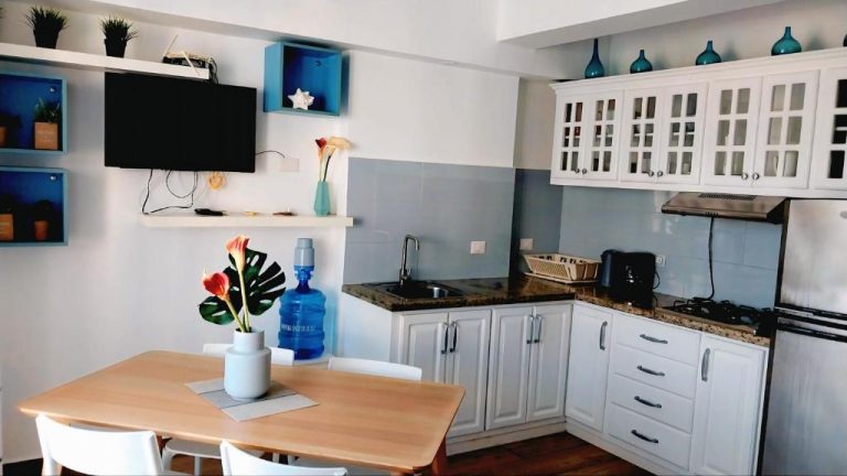 Cocina totalmente equipada con gabinetes blancos y comedor en Aruba Beach Hotel Punta Cana