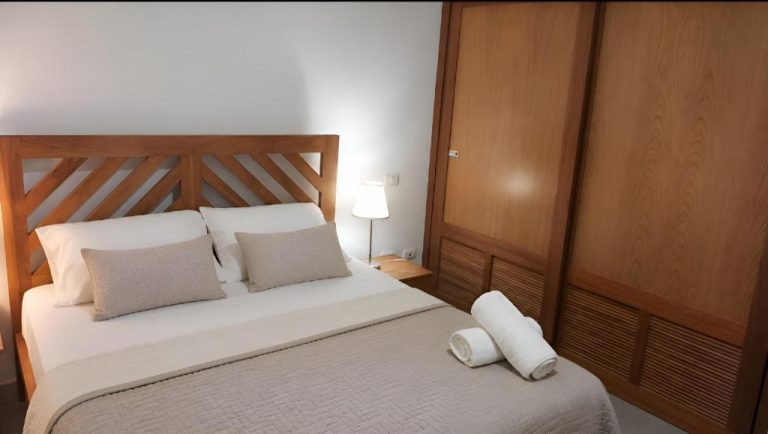 Habitación doble con cama matrimonial y cabecero de madera en Aruba Beach Hotel Punta Cana