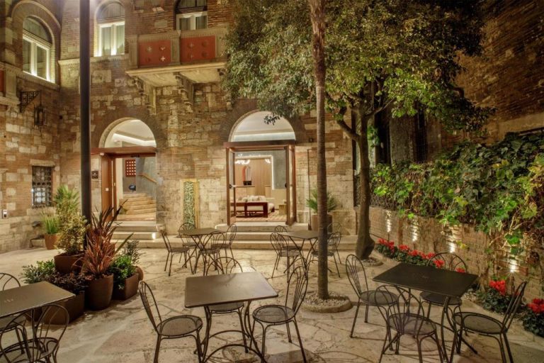 Terraza exterior con mesas y sillas de hierro en el Rosetta Hotel Perugia Tapestry Collection by Hilton