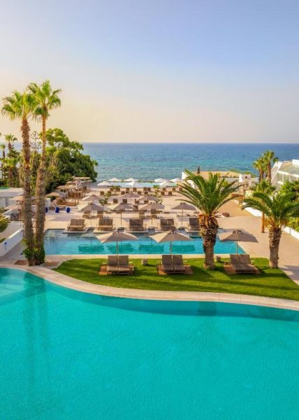 Piscina exterior con tumbonas y vistas al mar del Royal Azur Thalassa con palmeras y zona de playa