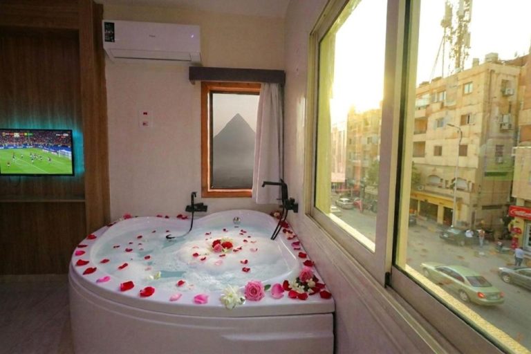 Jacuzzi romántico con pétalos de rosas y vistas a las Pirámides en Golden Lemon Pyramids View