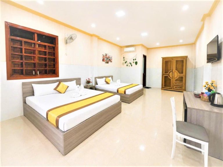 Habitación triple con dos camas y detalles amarillos en el Viora Hotel, amplia y luminosa