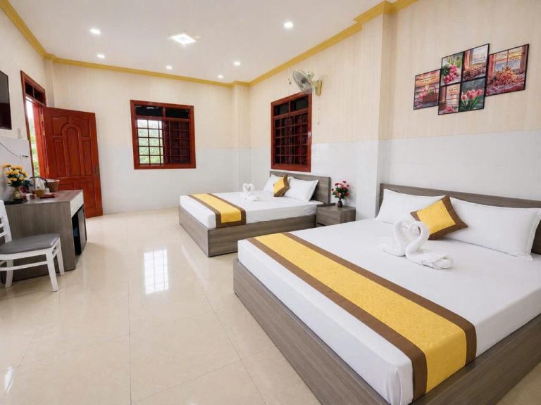 Habitación triple del Viora Hotel con dos camas dobles, decoración en amarillo y suelo de mármol blanco